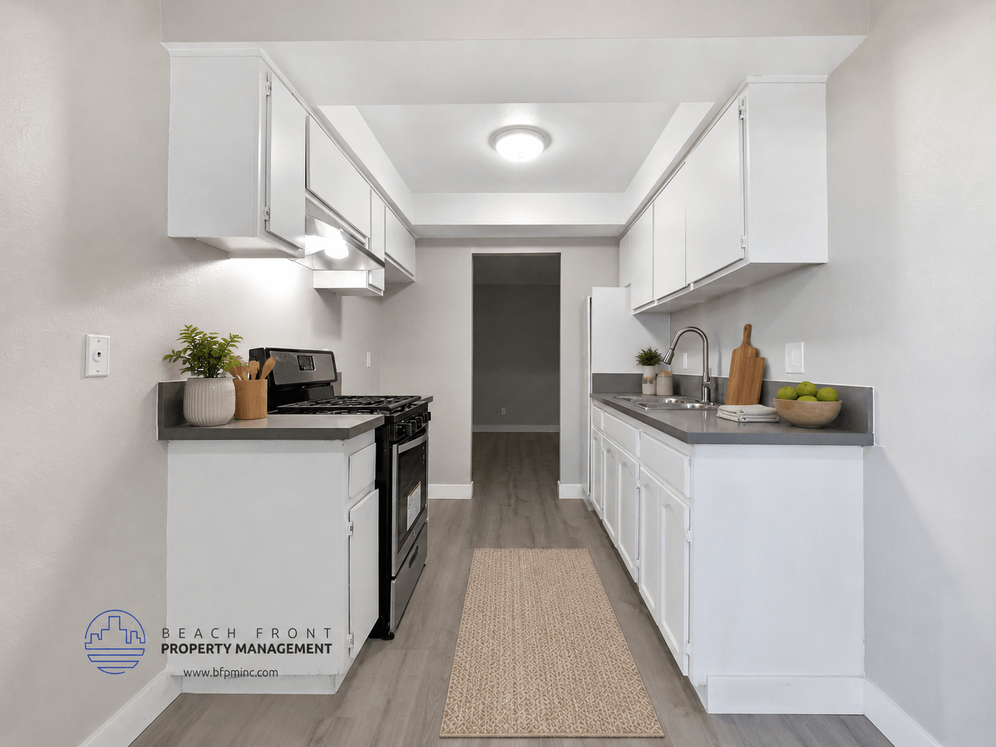 A kitchen with white cabinets and a black stove top oven.